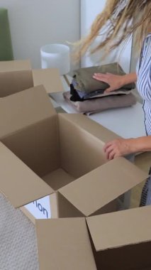 Kıyafetlerini bağış kutusuna koyan bir kadın. Yüksek kalite dikey 4k görüntü