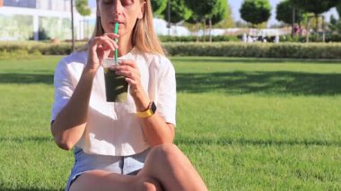 Çimlerin üzerinde buzlu kibrit çayı içen kadın. Yüksek kalite 4k görüntü