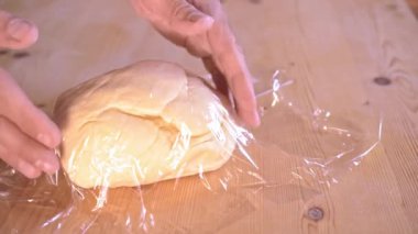 4k 60 fps, İtalyan bir aşçının doldurmaya başlamadan önce taze İtalyan makarnasını naylona sardığı yavaş çekim görüntüleri..