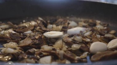 Porcini mantar ve soğan karışımının içine sarımsaklı karanfil düşer. 4K yavaş çekimde (120 fps,% 20 yavaşlatılmış) çekilen 45 derecelik bir açıyla makro yakın çekim, otantik İtalyan tarifini geliştirir.