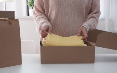 Çevrimiçi satış için karton paket kutusu paketleyen kadınlar. Kadın Satıcısı Teslimat Kutusunu Hazırlıyor. 