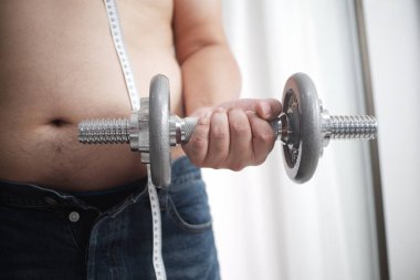 Şişman adamlar ağırlık kaldırarak egzersiz yapmaya başlarlar..