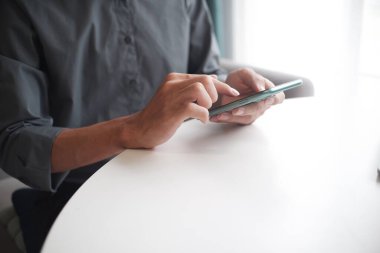 Cep telefonu kullanan iş adamının eli.