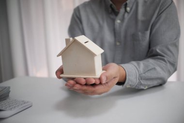 Emlakçı ve müşteri sözleşme imzalıyor, yeni bir ev alıyor.