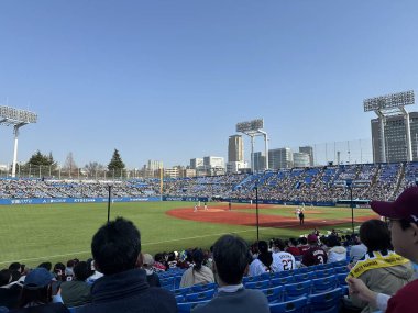 Tokyo, Japan - 16 Mar 2024: Baseball player playing the match in the stadium filled with fans. Yakult Swallows v/s Rakuten Eagles. clipart