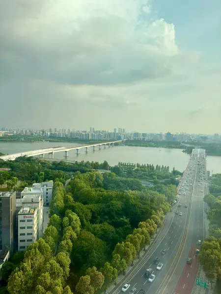 stock image Seoul, South Korea - 9 Aug 2024: Ariel view of Seoul city, you can see bridge over Han river, car moving to and fro and greenery surrounding it. Sky is clear, in the evening.