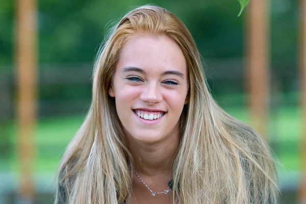 Frontalny Portret Uśmiechniętej Młodej Blondynki Niebieskimi Oczami Siedzącej Ogrodzie Mnóstwem — Zdjęcie stockowe
