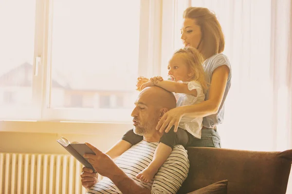 Dad Reads Daughter Mom Little Family Sofa Enveloped Warm Sunlight — Stock Photo, Image