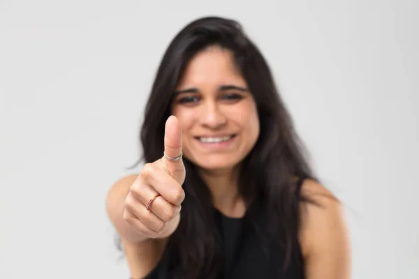模糊的图像 快乐的 微笑的印度女孩伸出她的手与大拇指对着我们 大拇指在前景中非常突出 她戴着一枚戒指 它表明了积极的一面 — 图库照片