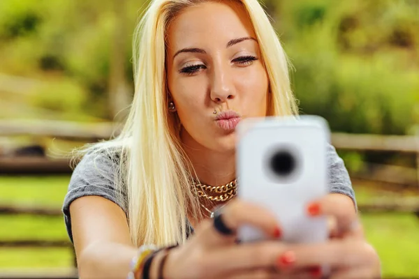 Красивая Блондинка Парке Длинные Волосы Держит Свой Мобильный Телефон Двумя — стоковое фото