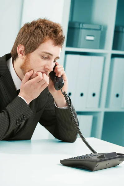 コミュニケーションのストレス 会社の固定電話で待っているか または聞くと心配そうな若い従業員は彼の釘をかむ 混乱が起きたか解雇されるか — ストック写真