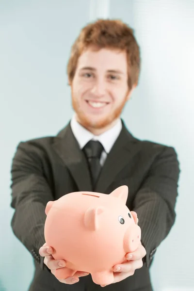 Close Piggy Bank Held Hand Leaning Forward Young Businessman Blurred — Stock Photo, Image