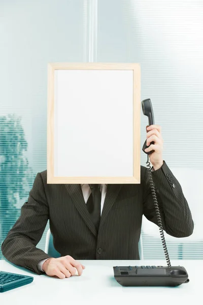 オフィスの看板の頭を持つ男が電話に応答します 手に携帯電話を持って腕を持ち上げ 耳を傾けるためにサインヘッドに引き寄せる コールセンターとカスタマーケアの概念 — ストック写真