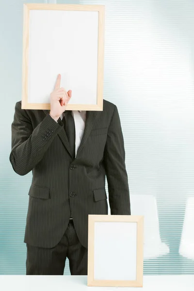 Ofiste Çerçevelenmiş Tabela Başlı Bir Adam Parmağını Yüzünün Önünde Duruyor — Stok fotoğraf