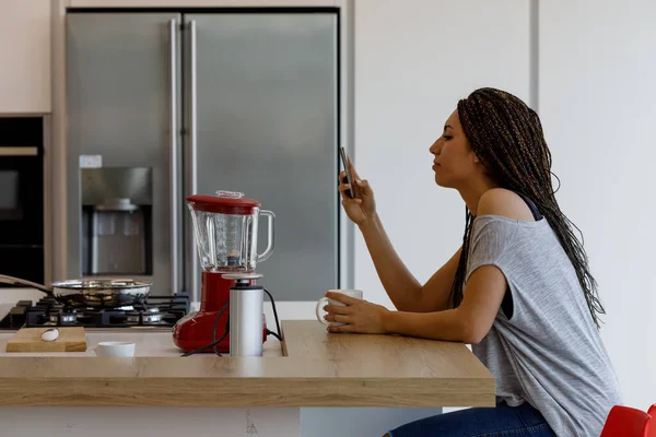 Die Junge Frau Benutzt Ihr Smartphone Der Küche Während Sie — Stockfoto