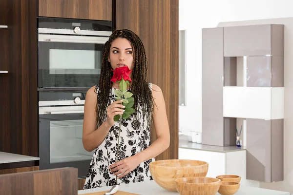 Young Woman Box Braids Modern Kitchen Smelling Red Rose Suspiciously — Stock Photo, Image