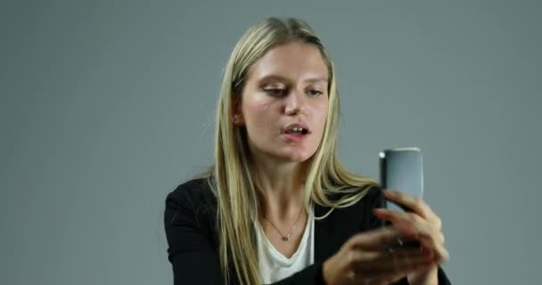 Young Blond Woman Uses Smartphone Neutral Background Quietly Suddenly Internet — Stock Video