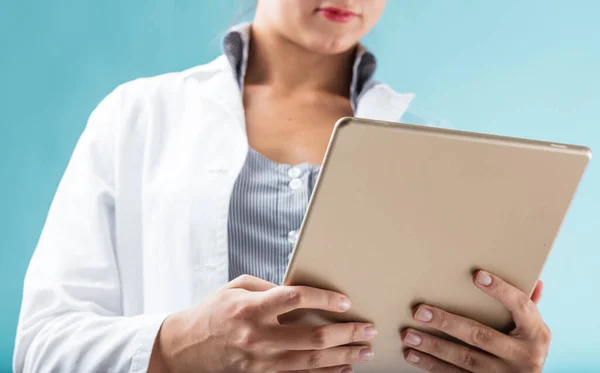 一个由女性手握着的数字平板电脑的特写 前景一片火红 穿着白色实验室外套的妇女可能是一名研究人员 科学家或家庭医生 她们使用计算机 — 图库照片