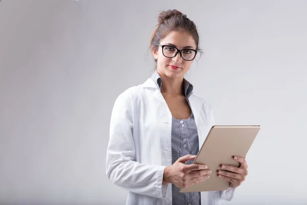 Woman Wearing White Lab Coat Glasses Holds Digital Tablet Looks — Stock Photo, Image