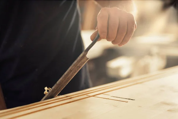 木匠使用手工切割工具对边缘进行倒角和切割 并按照自己的意愿 以正常或不规则的方式顺利地去除卷曲和碎屑 只有技艺高超的工匠才能独树一帜 — 图库照片