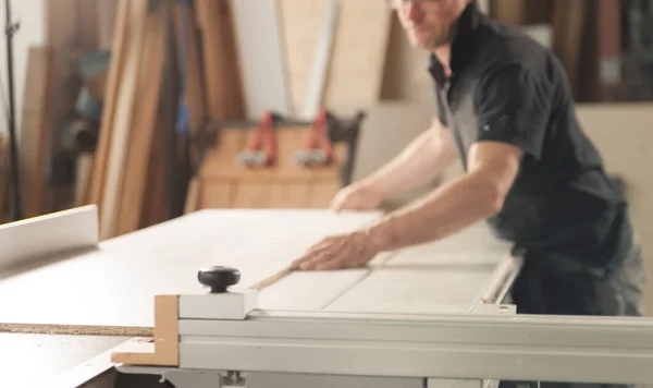 自分の工房で職人をしている 一人の男は 木製の部品や表面を見て および仕上げするために適切なツール 棚で動作します — ストック写真