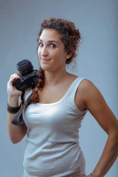 Woman in sports tank top and camera. Loves taking action photos in nature, going on adventures and safari photos, traveling and exploring.