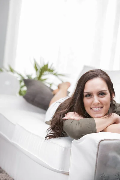 Een Lachende Vrouw Ligt Thuis Met Haar Gezicht Bank Heeft — Stockfoto