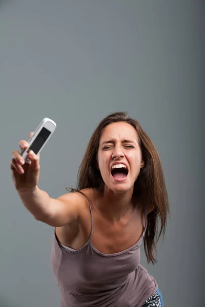 운동을 핸드폰을 던지는 여성은 분노에 폭력적 비명을 내보낸다 그녀는 완전히 — 스톡 사진