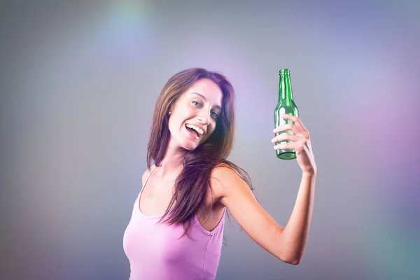 拿着绿色瓶子的女孩庆祝一下 显得有点醉了 穿着粉色背心的年轻女人看起来很开心 还有点醉了 瓶子可能是啤酒 她很开心 有一部分 — 图库照片