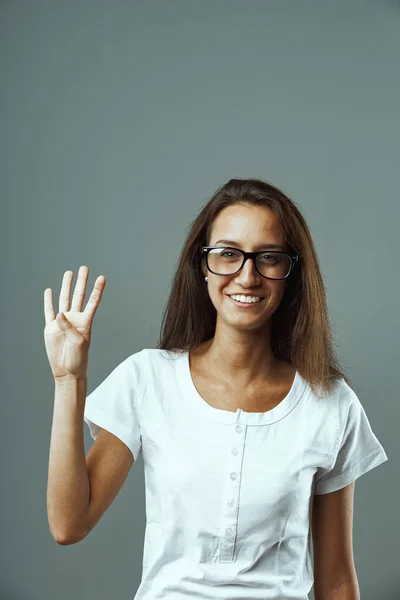 Νεαρή Γυναίκα Γυαλιά Λευκό Πουκάμισο Μετωπικό Πορτραίτο Σηκώνοντας Χέρι Τέσσερα — Φωτογραφία Αρχείου
