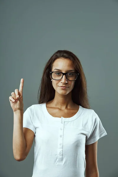 Ung Kvinna Med Glasögon Vit Skjorta Porträtterad Framifrån Lyfta Hand — Stockfoto