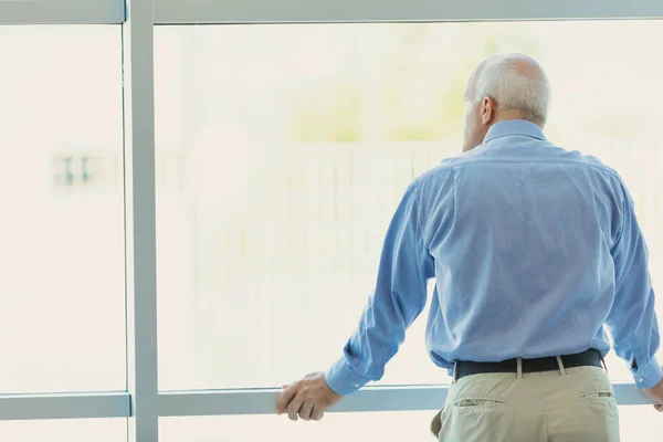 Gray Haired Almost Balding Man Looks Out Large Bright Modern — Stock Photo, Image