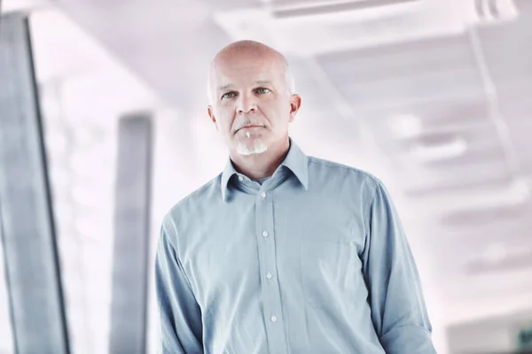 stock image dynamic image of an elderly man absorbed in his own thoughts walking in a modern or technological environment, confident in the future and in humanity, with a neutral gaze