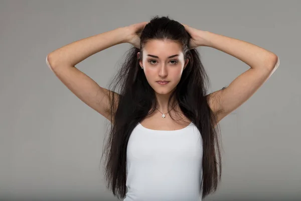 Très Jeune Femme Dans Débardeur Blanc Rassemble Ses Cheveux Mettant — Photo