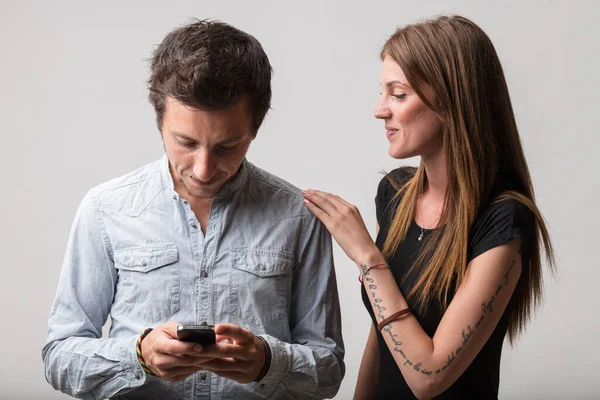 Bir Adam Akıllı Telefonuna Sırıtıyor Kız Arkadaşı Izliyor Onun Oyun — Stok fotoğraf