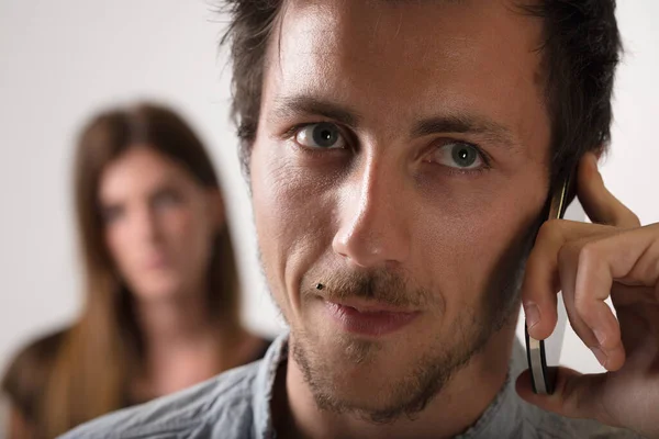 Ein Mann Telefon Steht Mittelpunkt Während Eine Zweifelnde Frau Hintergrund — Stockfoto