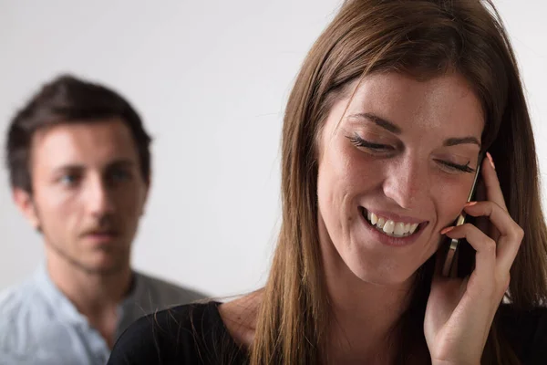 Focus Woman Engaged Smartphone Call Suspicious Anxious Young Man Feeling — Stock Photo, Image
