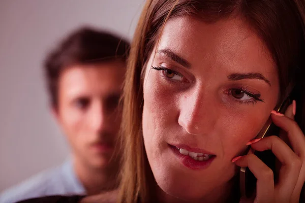 Жінка Телефонному Дзвінку Займає Передній План Розмитим Підозрілим Молодим Чоловіком — стокове фото
