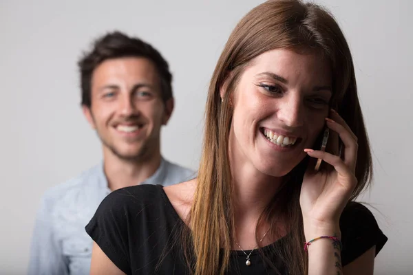 Telefonla Konuşan Bir Kadın Planda Bulanık Şüpheli Bir Genç Adamla — Stok fotoğraf