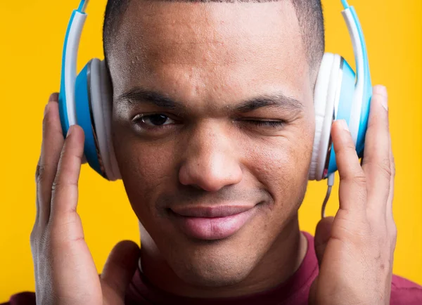 Joven Guiña Ojo Mientras Escucha Apasionadamente Música Podcast Sosteniendo Auriculares — Foto de Stock
