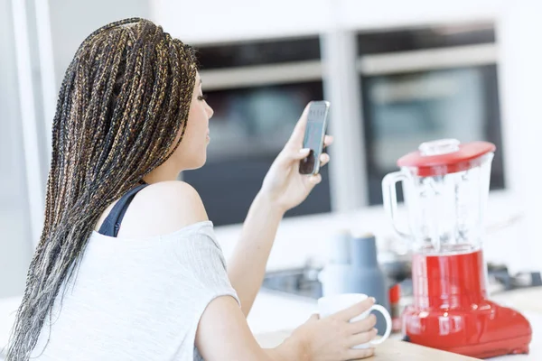 Své Prostorné Kuchyni Mladá Žena Krabicovými Copánky Používá Svůj Smartphone — Stock fotografie