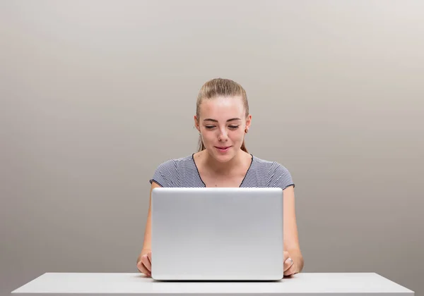 漂亮的年轻女人坐在书桌前 带着笔记本电脑 快乐极了 积极参与互联网和社交媒体上发生的事情 积极参与世界的现代化 改变和改变世界 — 图库照片