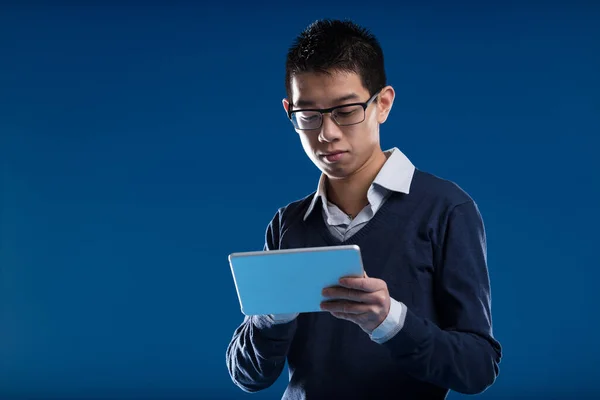 Asian Man Glasses Absorbed His Tablet Checks News Blue Backdrop — Stock Photo, Image