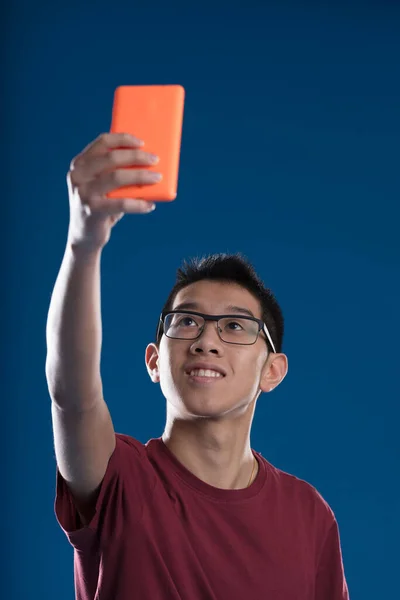Aasialainen Ottaa Selfien Oranssi Älypuhelin Tai Ehkä Luoda Sisältöä Live — kuvapankkivalokuva