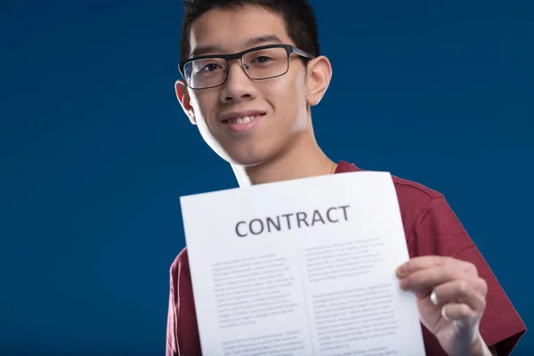 快乐的东亚年轻人 拿着一个合同 展示双赢协议互惠互利 或证明他的谈判技巧 — 图库照片