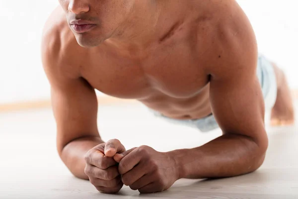 一个身份不明的黑人用手肘在地上表演木板 他引人注目的胸肌和腹肌证明运动能增强吸引力和健康 — 图库照片