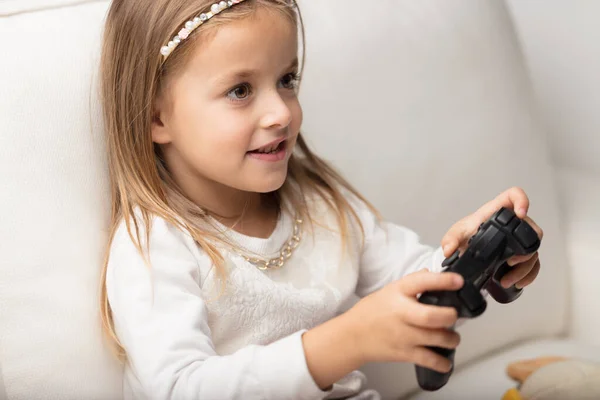 Στο Σπίτι Ένα Μικρό Κορίτσι Απολαμβάνει Παίζει Βιντεοπαιχνίδια Καθοδηγούμενη Από — Φωτογραφία Αρχείου