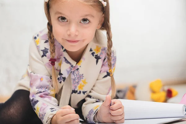 Ein Kleines Mädchen Mit Hochgestecktem Haar Und Stirnband Sitzt Beim — Stockfoto