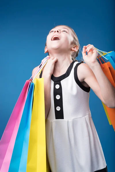青い背景では 少女は高社会の買い物客 純粋な喜びのふりをする — ストック写真