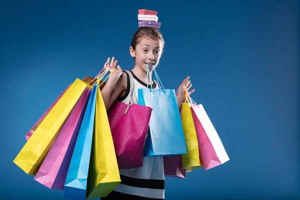 소녀는 다채로운 드레스 기쁨으로 가득한 쇼핑객을 모방합니다 — 스톡 사진